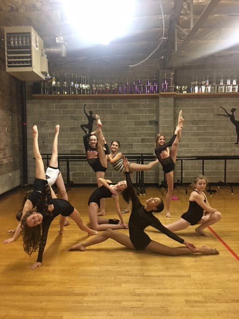 Performing company dancers striking poses in the studio